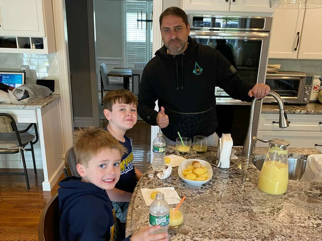 A JK-Fish team member and two kids taking a break in the kitchen